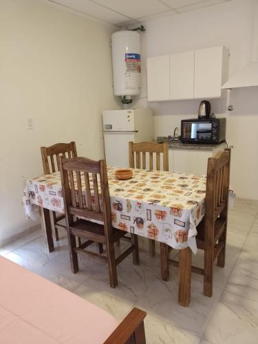 cocina con mesa, sillas y microondas en TUNUYAN Apart en Tunuyán