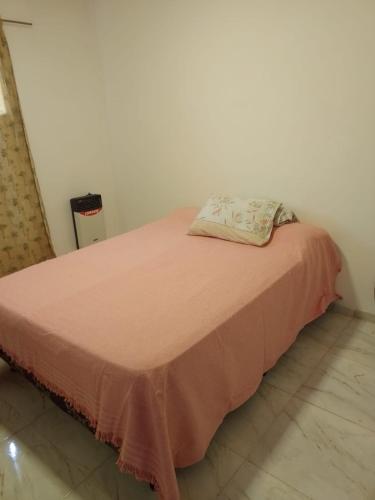 Cama en habitación con manta rosa en TUNUYAN Apart en Tunuyán