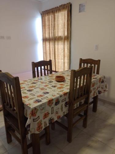 a dining room table with four chairs and a tablecloth with animals at TUNUYAN Apart in Tunuyán