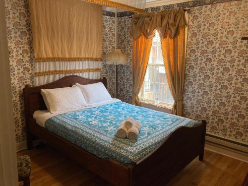 a bedroom with a bed with a pair of shoes on it at St. George Hotel in Barkerville