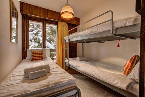 zwei Etagenbetten in einem Zimmer mit Fenster in der Unterkunft Appartement LaForet 86 in La Tzoumaz