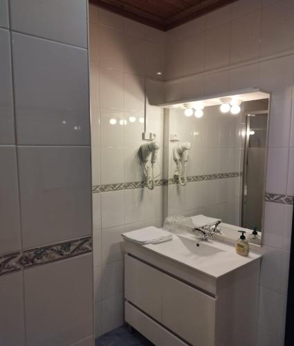 a white bathroom with a sink and a mirror at Casa de Santa Ana da Beira in Seia