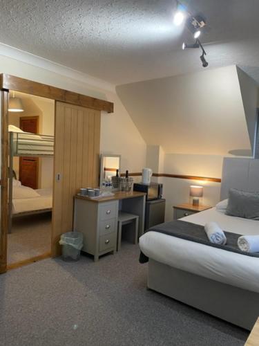 een hotelkamer met een bed, een bureau en een slaapkamer bij Highland Stays - Rushfield House Rooms in Fort William