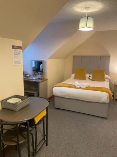 a bedroom with a bed and a desk and a table at Highland Stays - Rushfield House Rooms in Fort William