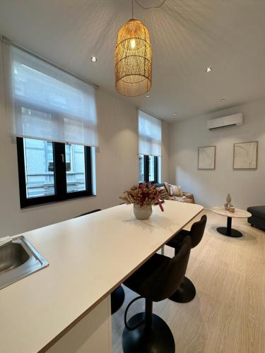 uma cozinha com um balcão, uma mesa e cadeiras em Appartement lumineux hyper centre em Liège