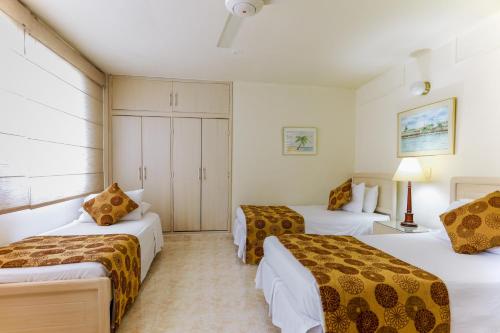 a hotel room with three beds in a room at Hotel San Carlos in Barrancabermeja