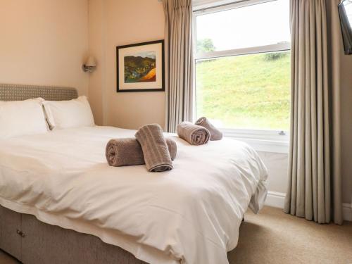 a bedroom with a bed with towels on it at Dales Cottage in Grassington