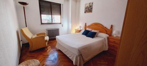 Un dormitorio con una cama y una silla y una ventana. en Imperial, 9, en Salamanca