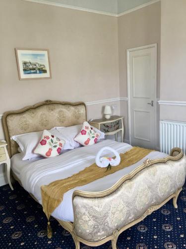 a bedroom with a large bed with pink and white pillows at Penzance Seaside studios in Penzance