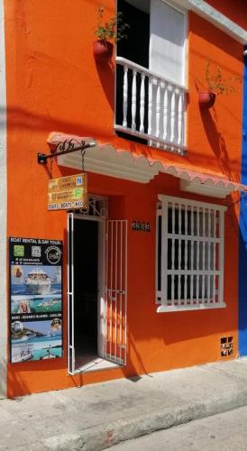 un edificio naranja con puerta y balcón en Casa 39-33 en Cartagena de Indias