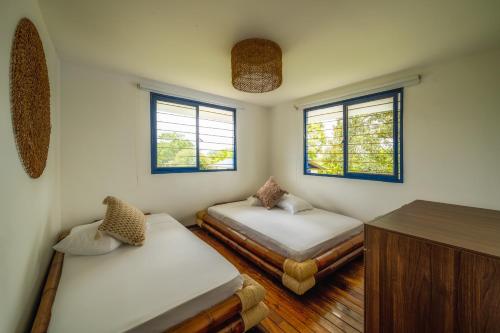 a room with two beds and two windows at Finca el Bosque in Montenegro