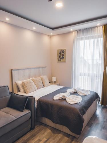a bedroom with a large bed and a couch at Milmari Premier - Daisy Apartments in Kopaonik