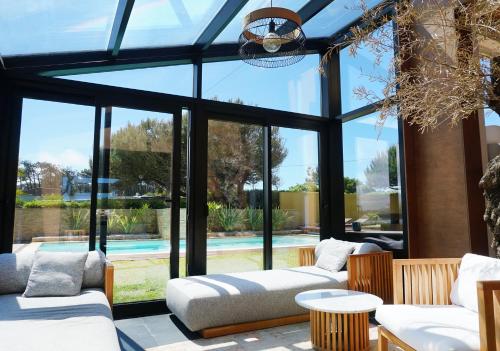 a living room with glass windows and a pool at Sense of Ofir in Fão