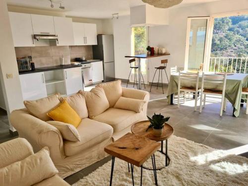 ein Wohnzimmer mit einem Sofa und einem Tisch in der Unterkunft Vue panoramique - résidence calme - St Raphaël in Saint-Raphaël