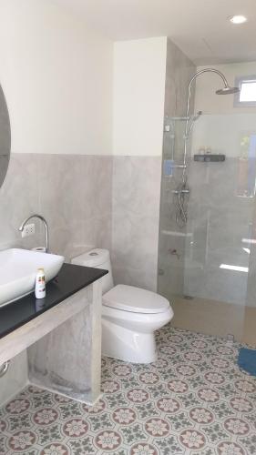 a bathroom with a toilet and a sink and a shower at RadHut in Chalong