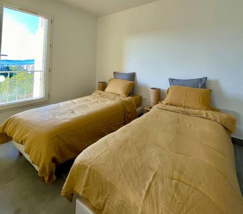 2 Betten in einem Zimmer mit Fenster in der Unterkunft Vue panoramique - résidence calme - St Raphaël in Saint-Raphaël