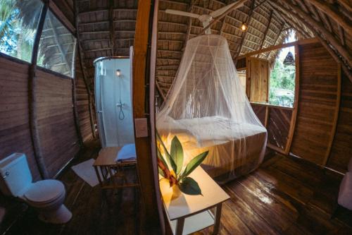 a room with a bed and a shower and a toilet at La Colmena RD in Santa Bárbara de Samaná