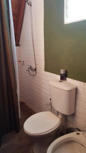 uma casa de banho com um WC branco e um espelho. em Cabañas don luis 