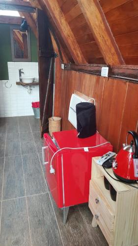 uma cozinha com um aparelho vermelho num quarto em Cabañas don luis 