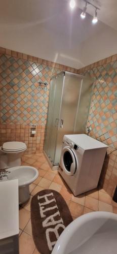 a bathroom with a toilet and a washing machine at Amici di Calabria in Scalea
