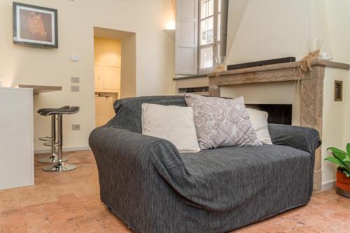 a gray couch in a living room with a fireplace at Il Loft di Quintino in Parma