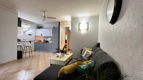 a living room with a couch and a kitchen at Tropical Morabeza Apartment Santa Maria in Santa Maria