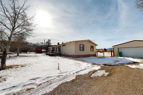 a house with snow on the ground next to a building at Yatahey in South Fork