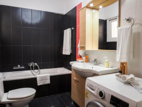 ein Badezimmer mit einem WC, einem Waschbecken und einer Waschmaschine in der Unterkunft Sea end Sun in Volos