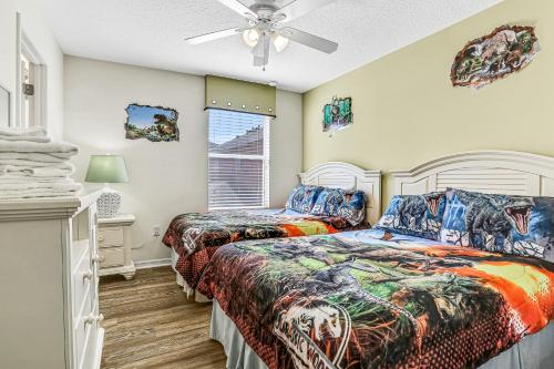 Un dormitorio con dos camas y un ventilador de techo. en The Warmth of Florida - BellaVida Resort, en Kissimmee