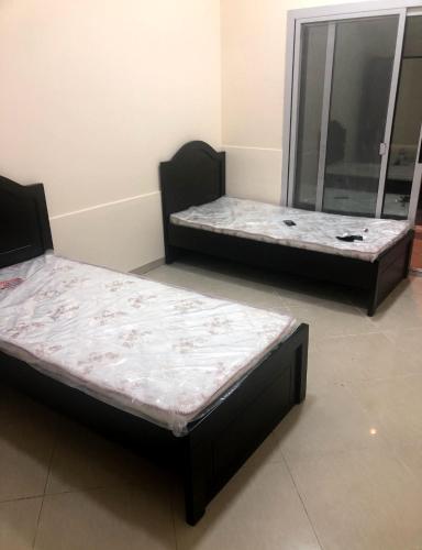 two beds sitting in a room with a mirror at Furnished Apartment in Dubai