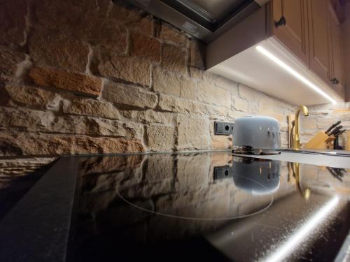 a kitchen with a counter top and a brick wall at klein&fein in Neustift im Stubaital