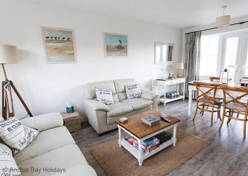 a living room with a couch and a table at Lees Plaice - Part of the The Bay Filey Holiday Village with pool, gym and direct beach access, pub, restaurant, tennis and meadows walks in Filey