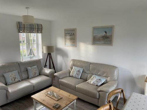 a living room with two couches and a coffee table at Lees Plaice - Part of the The Bay Filey Holiday Village with pool, gym and direct beach access, pub, restaurant, tennis and meadows walks in Filey