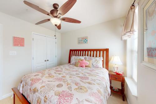 1 dormitorio con 1 cama y ventilador de techo en The Sand Bar at Seaside Village en Ocean City