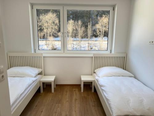 two beds in a room with two windows at Apartment 183 Stubaital in Fulpmes