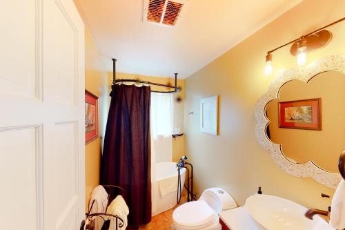 a bathroom with a sink and a toilet and a mirror at Hayward Home in Eugene