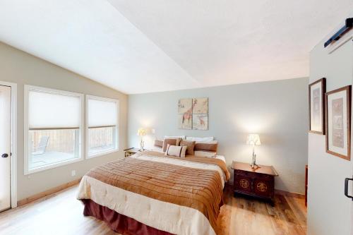 a bedroom with a large bed and two windows at Hayward Home in Eugene