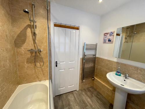 uma casa de banho com um chuveiro e um lavatório. em Marine Apartment Whitley Bay Seaside Location Free Onsite Parking em Whitley Bay