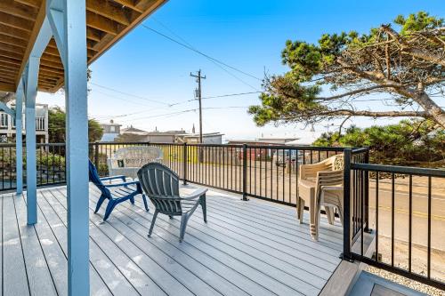 a porch with two chairs and a table on it at The Boat House Retreat in Lincoln City