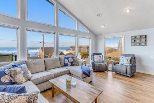 a living room with a couch and chairs and windows at The Boat House Retreat in Lincoln City