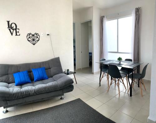 a living room with a couch and a table with blue pillows at Departamento 2 habitaciones vista a la alberca Sky by EITA in Cancún