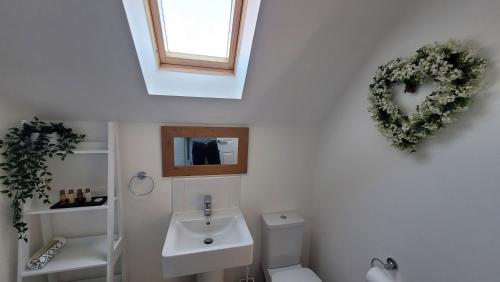 a bathroom with a white toilet and a sink at Puddleduck Cottage in Filey