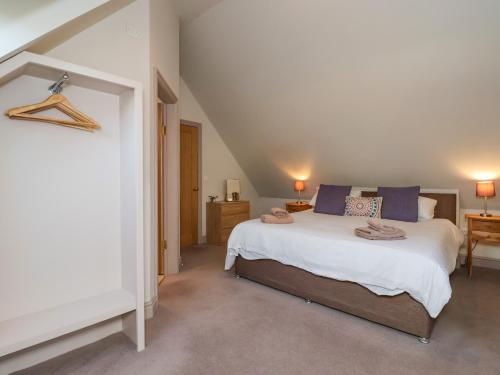 a bedroom with a large white bed with blue pillows at The Dower House Cottage in Carthorpe