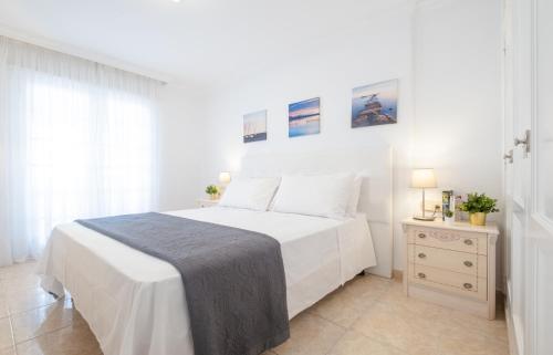 ロス・クリスティアーノスにあるLa Maricita Cristianos - Beach Front & Sea Viewの白いベッドルーム(大型ベッド1台、ナイトスタンド付)