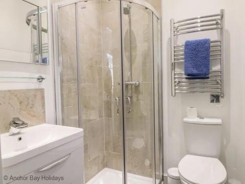 a bathroom with a shower and a toilet and a sink at Sea-Renity in Filey