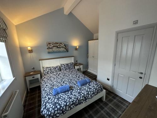 a bedroom with a bed with blue pillows at Sea-Renity in Filey