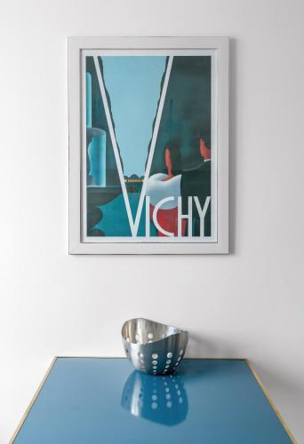 a bowl on a table in front of a picture at Appartement design La Petite Europe - Idéal Curistes in Vichy