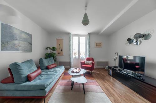 uma sala de estar com um sofá e uma televisão em Appartement design La Petite Europe - Idéal Curistes em Vichy