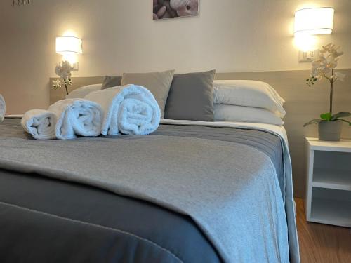 1 dormitorio con 1 cama con toallas en Hotel Augustus, en Milano Marittima