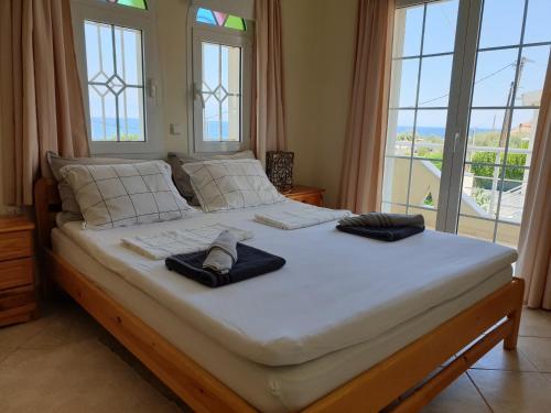 a large bed with two towels on it with windows at Villa Bianca in Káto Pitsá